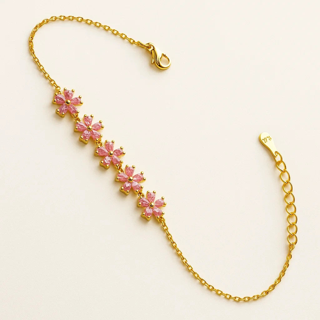 A gold-plated 925 sterling silver chain bracelet with five flower-shaped links set with pink marquise cubic zirconia stones.