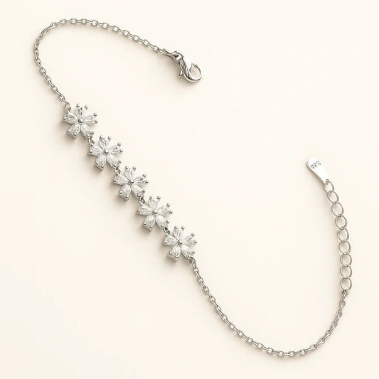 Silver bracelet with floral diamond charms on a light beige background